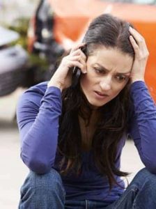 Woman making a call after a car accident