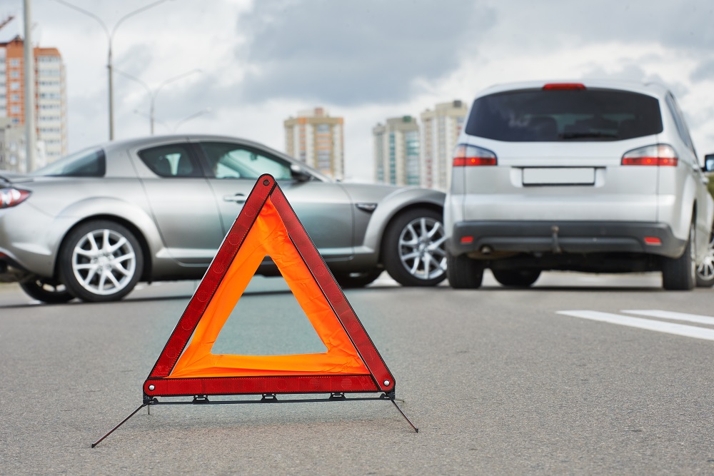 Two cars crash from changing lanes in the highway.