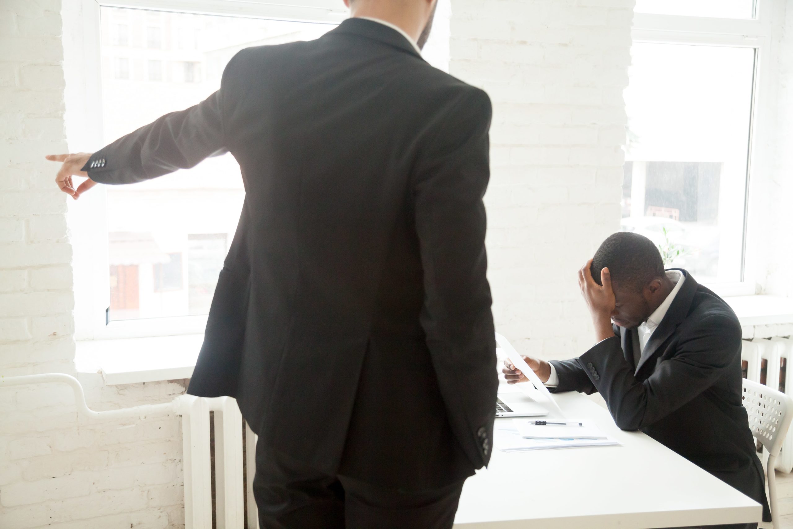 Angry employer pointing the door to oust employee.