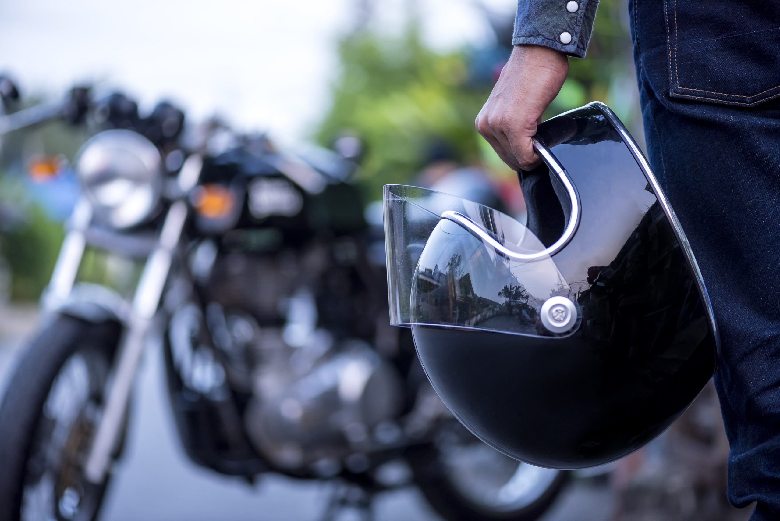 Driver holding a helmet for protection.