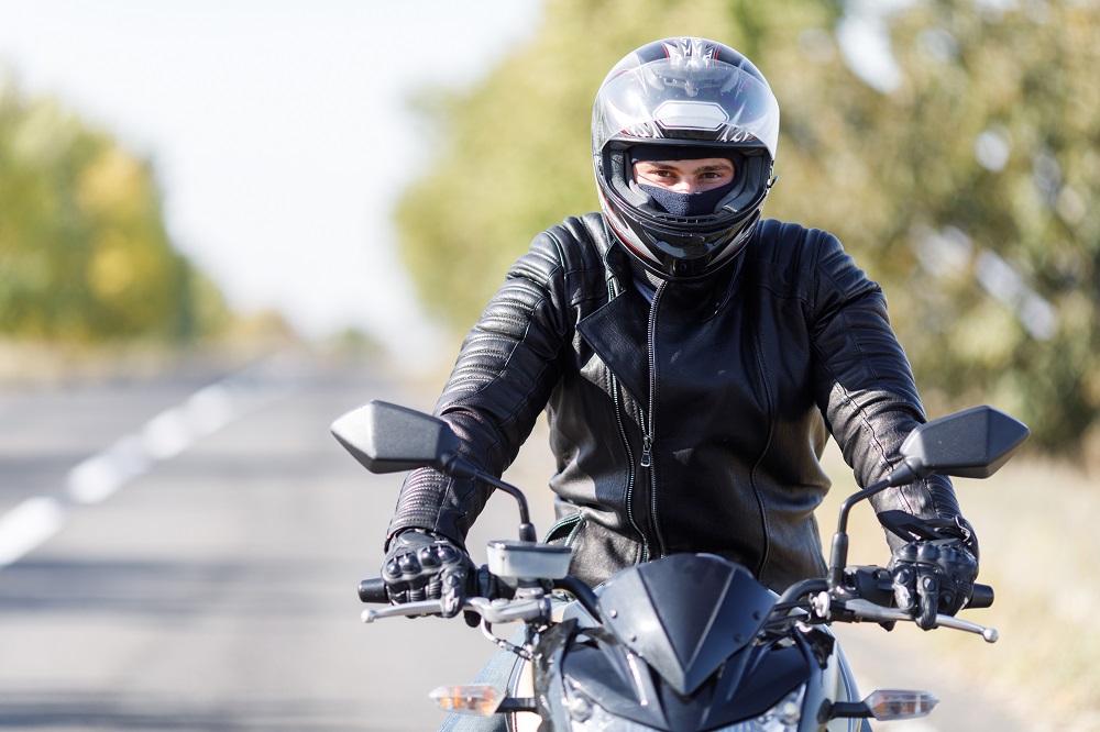 Motorcycle rider wearing helmet for safety.