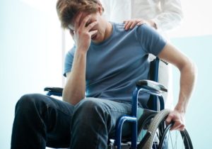 Depressed man in wheelchair suffering from paraplegia.