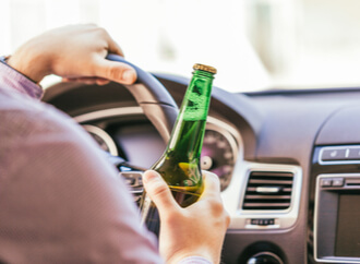 Driver with an alcoholic beverage in their hand