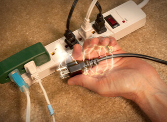 a person receiving an electrical shock from a power strip