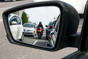 A motorcycle lane splitting and about to cause an accident.