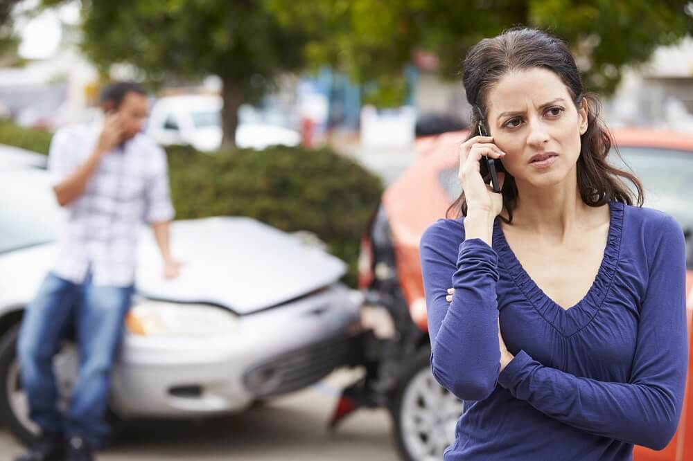 Woman driver reporting car accident to police.