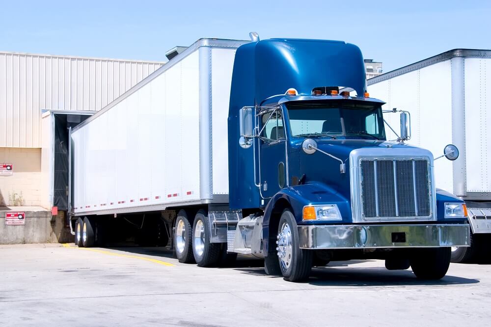 Blue tractor trailer truck in parking.