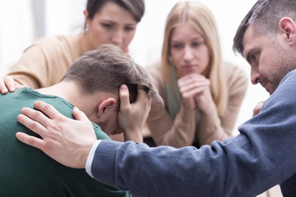 Young man suffering with PTSD in counseling session.