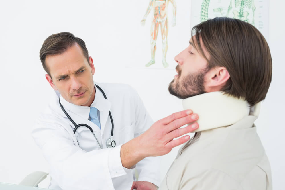 Doctor checking neck injury on patient.