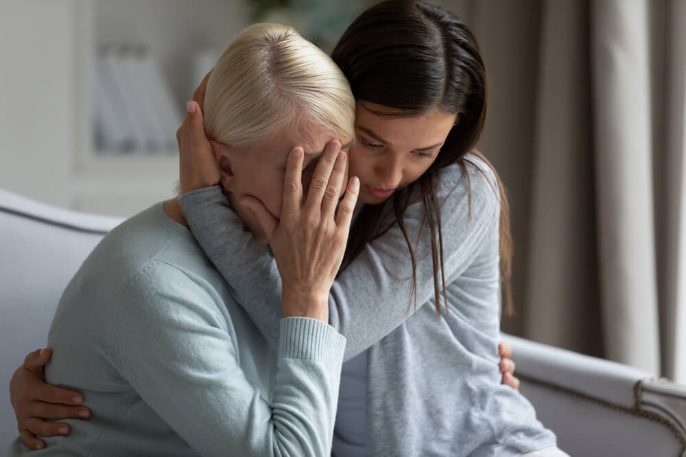 Daughter hugging her mother to comfort.