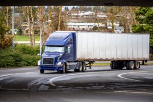 Tractor trailer truck passing under the bridge.