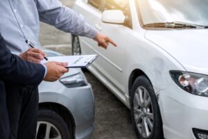 Insurance agent checking damage car from accident.