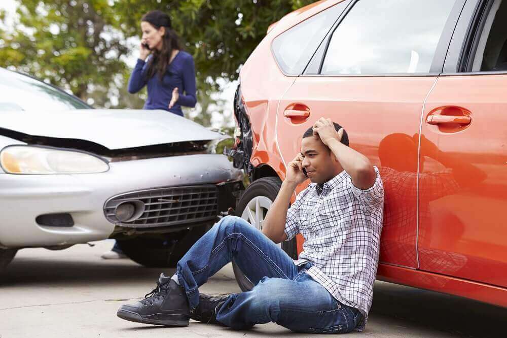 Young uninsured driver calling insurance to report accident.