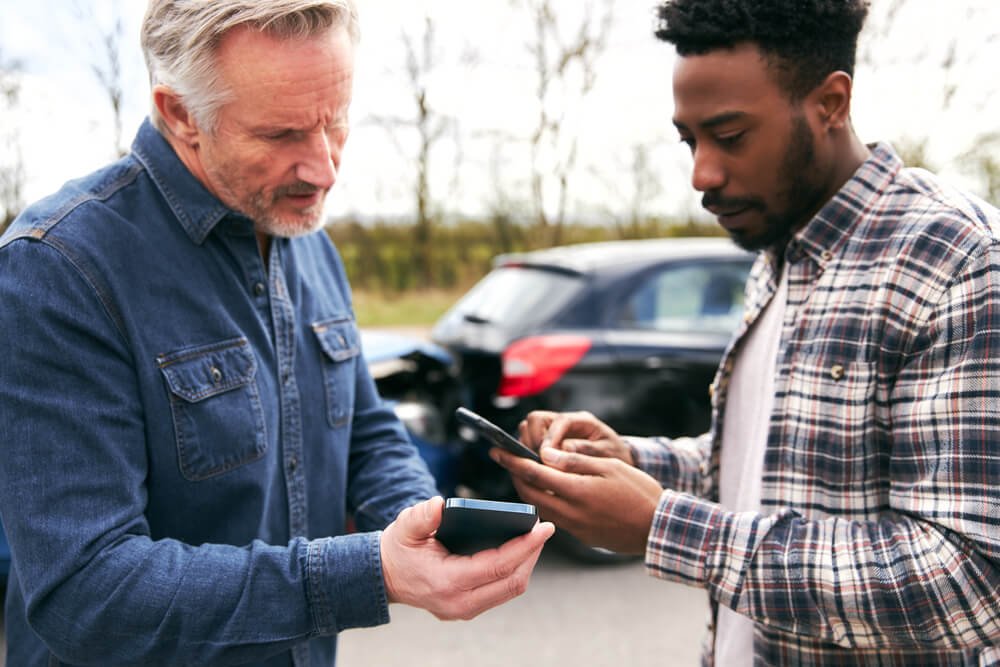 Drivers involved in accident exchanging details for insurance claims.