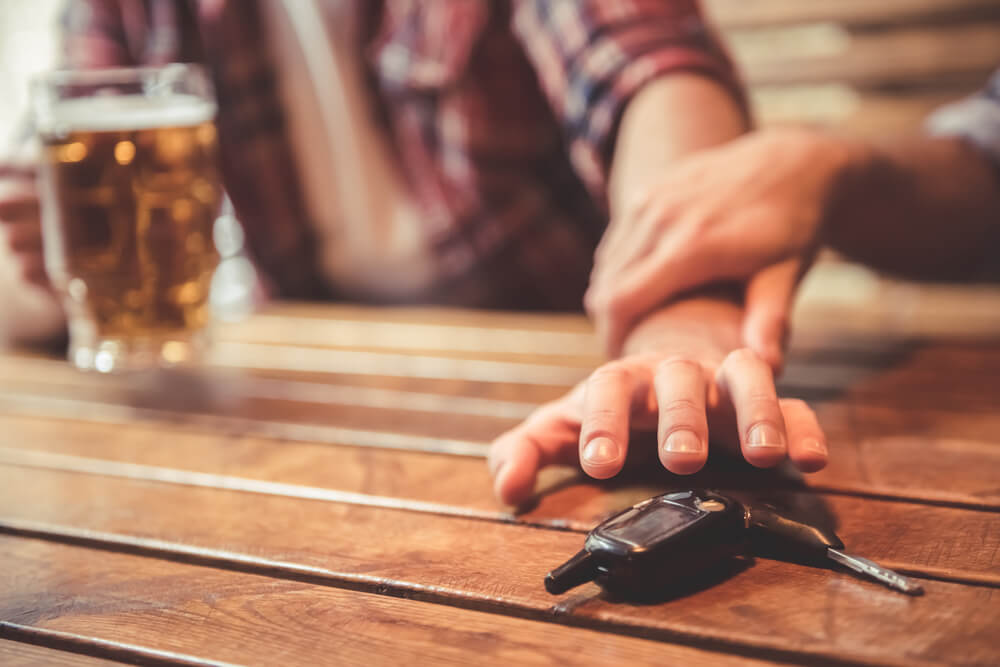 Drunk driver in the dram shop reaching his car keys.