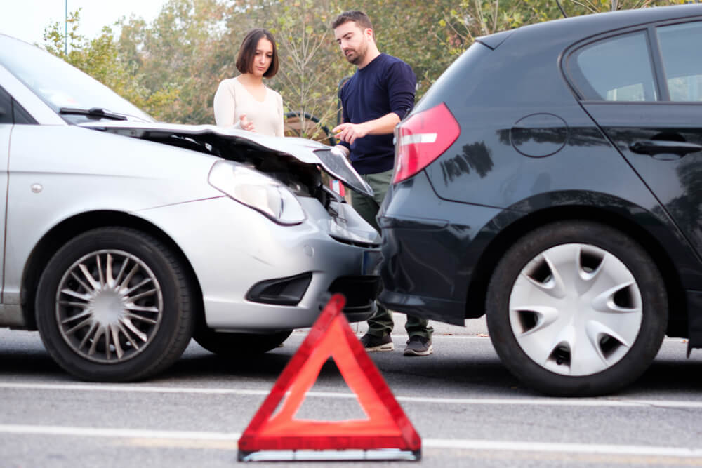 Drivers involved in car accident exchanging contact details.