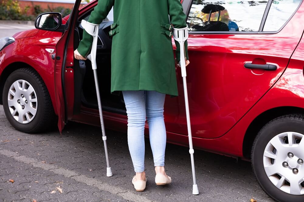 Injured woman from car accident on crutches