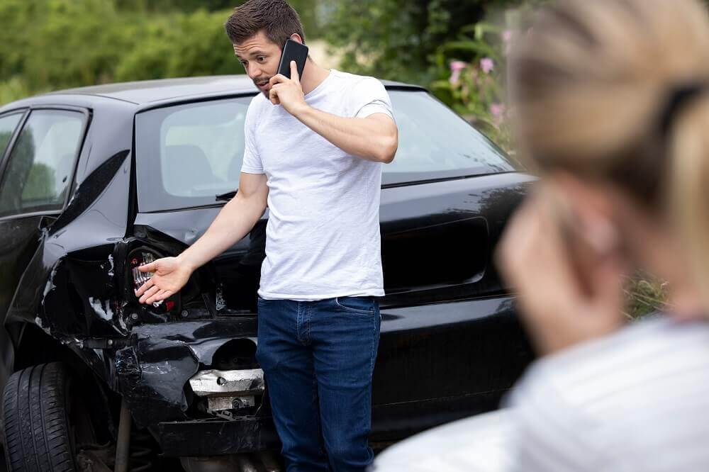 Driver calling his insurance company to report accident.