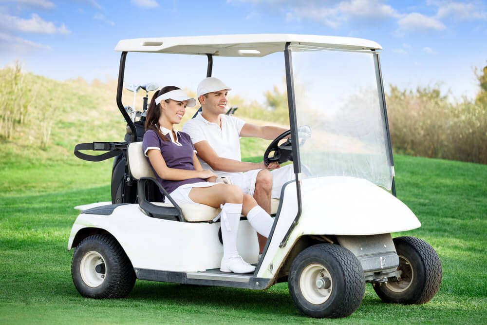 Couple riding a golfcart strolling.