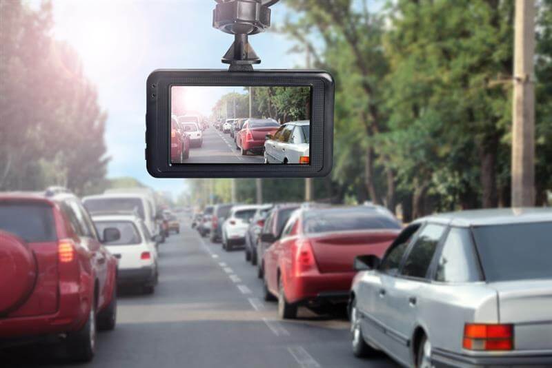 Modern dashboard camera mounted in car, view of road during driving.