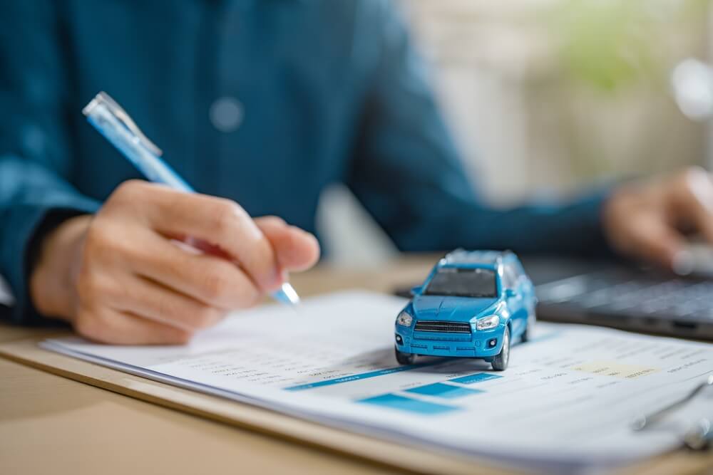 Man signing a car insurance policy.