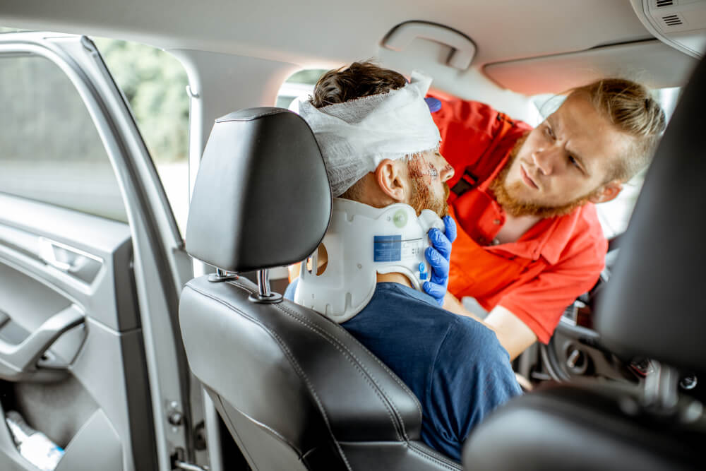 Driver rescued by paramedics treating first aid.